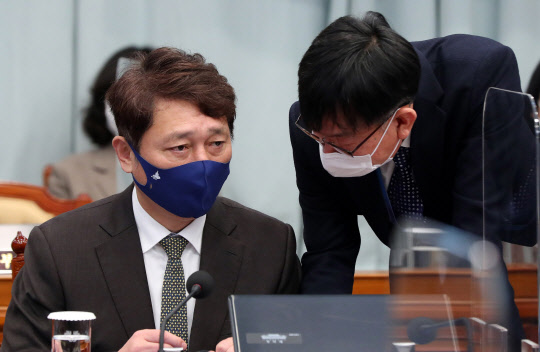 최재성 정무수석(왼쪽)이 2일 청와대에서 열린 영상 국무회의에 참석한 모습. 김상조 청와대 정책실장(오른쪽)과 대화하고 있다. 연합뉴스.